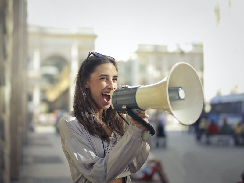 A woman using a megaphone to get the word out about her new business